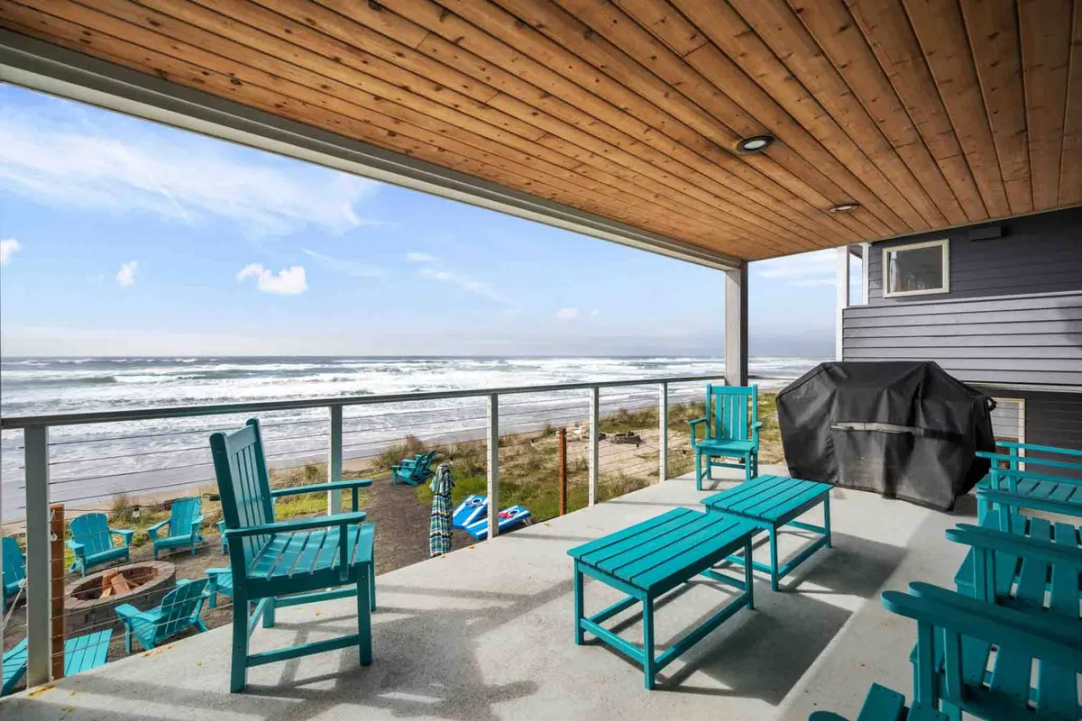 An exterior deck with comfortable outdoor seating, a barbecue grill, and a sweeping ocean view. The space is set for socializing, dining, and soaking in the coastal ambiance, whether during sunrise coffee or sunset dinners.