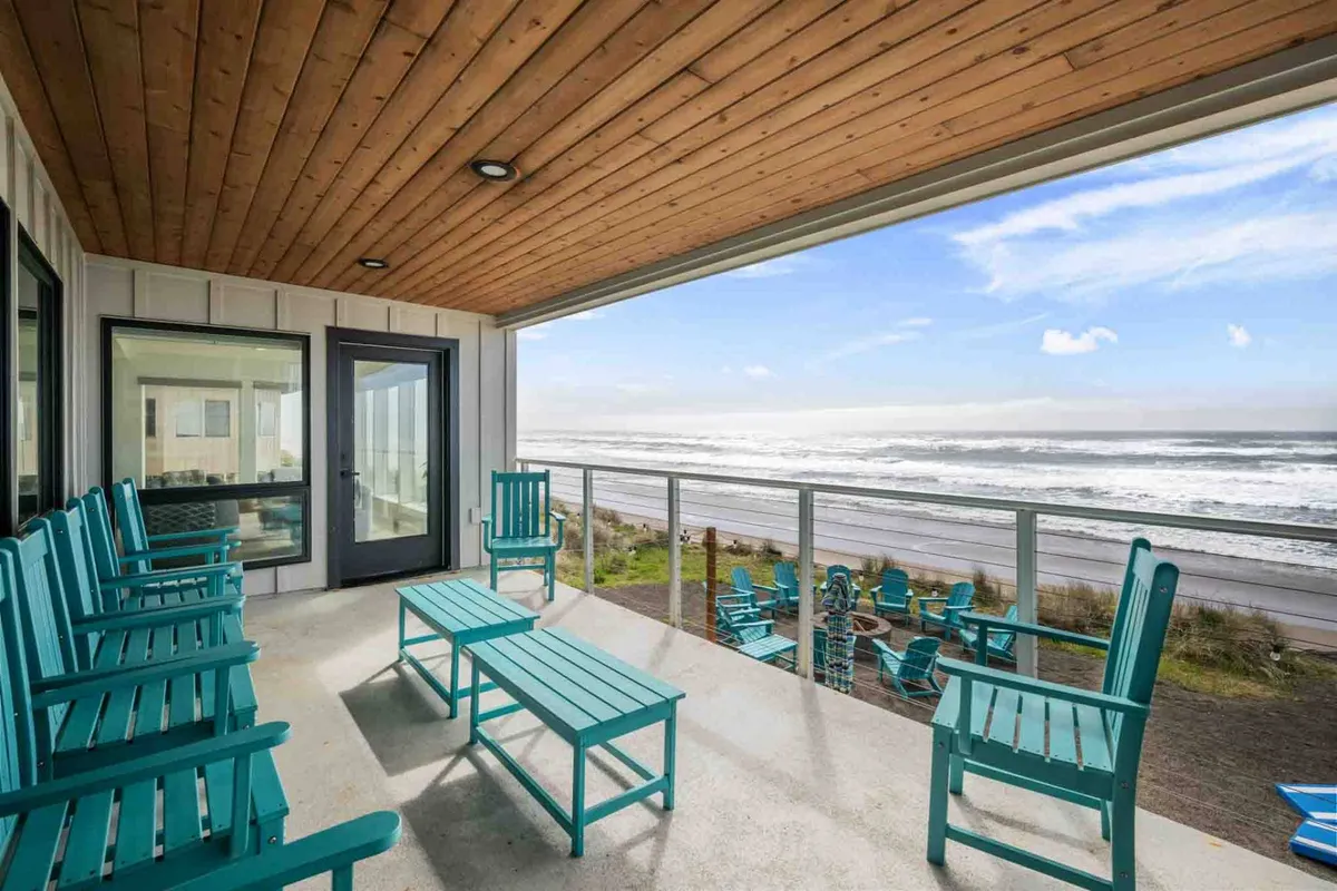 A cozy outdoor seating area under a wooden ceiling, facing the ocean. The peaceful setting invites families to gather, share stories, or enjoy s’mores by the fire pit as the waves roll in.